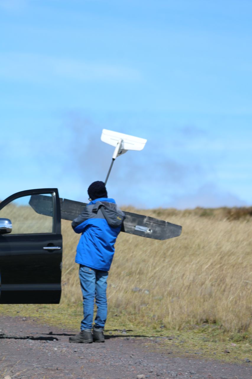 Manual transport of the fixed-wing drone to the takeoff point.