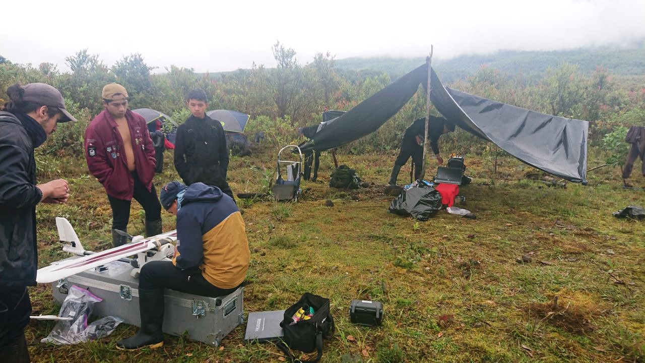 Assembly, review, and configuration of the fixed-wing drone by the team at the base camp.