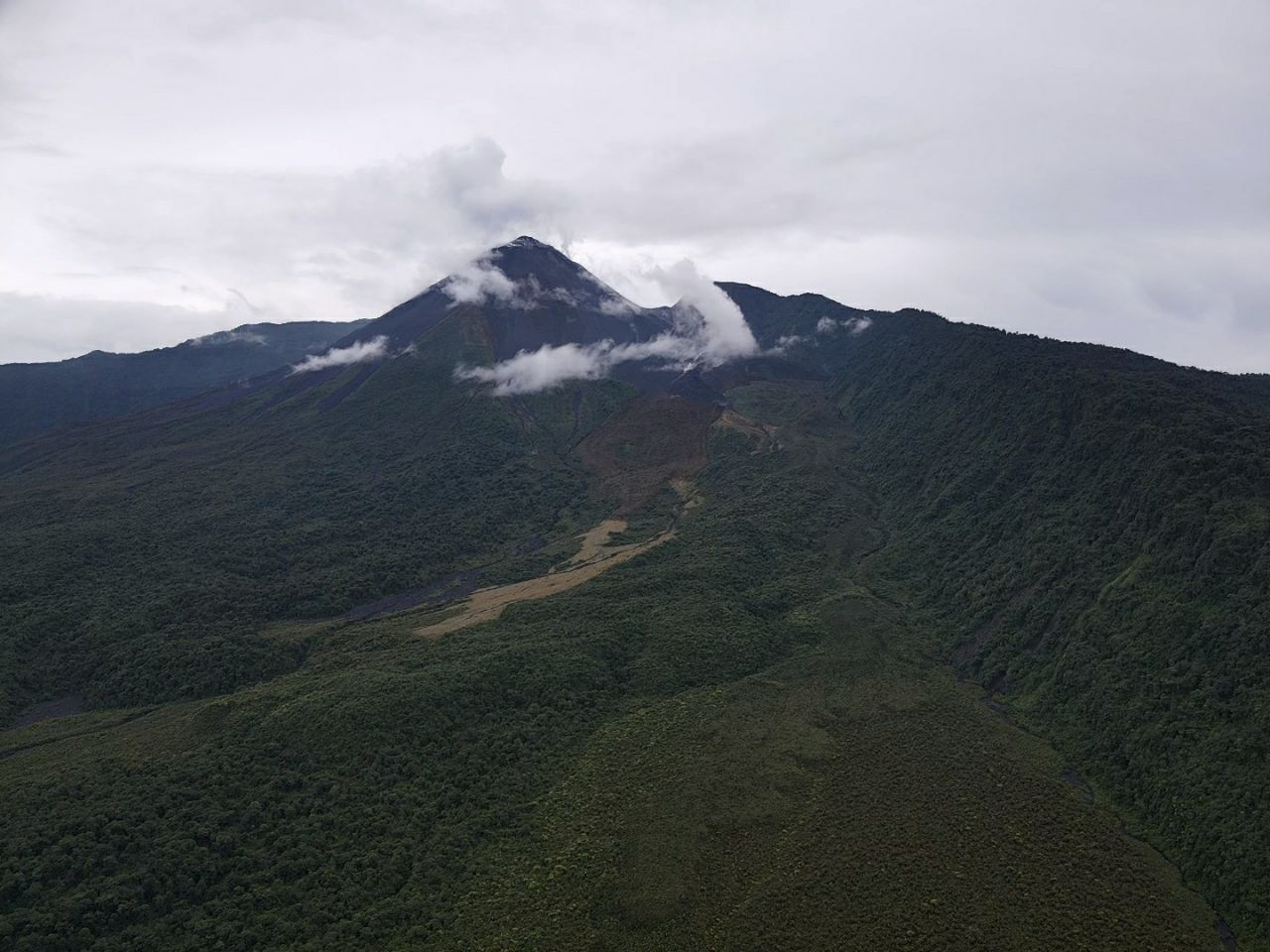 General view of the Reventador volcano and its relief surrounded by low cloud cover.